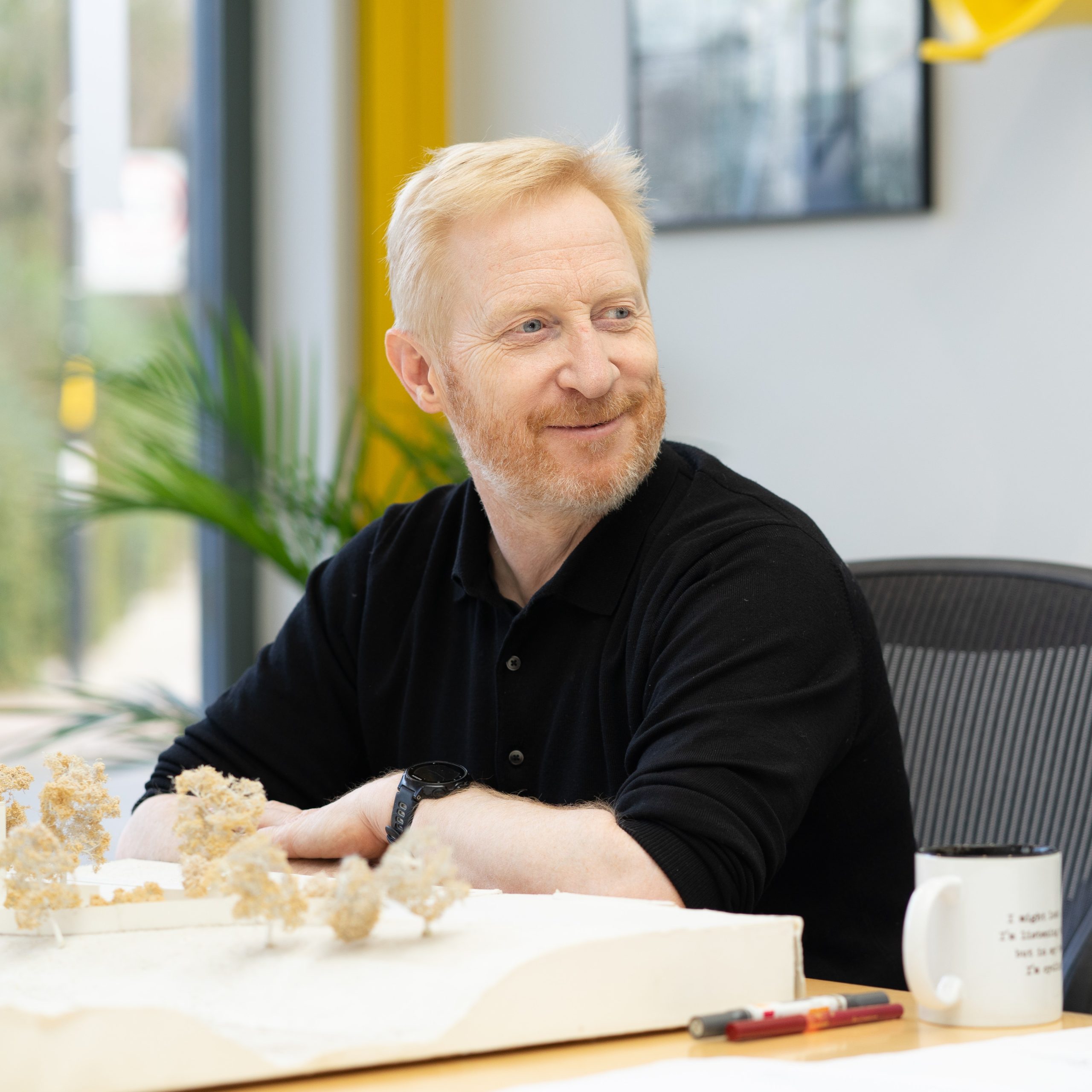 Richard Dudzicki sitting at a table infront of an architectural model