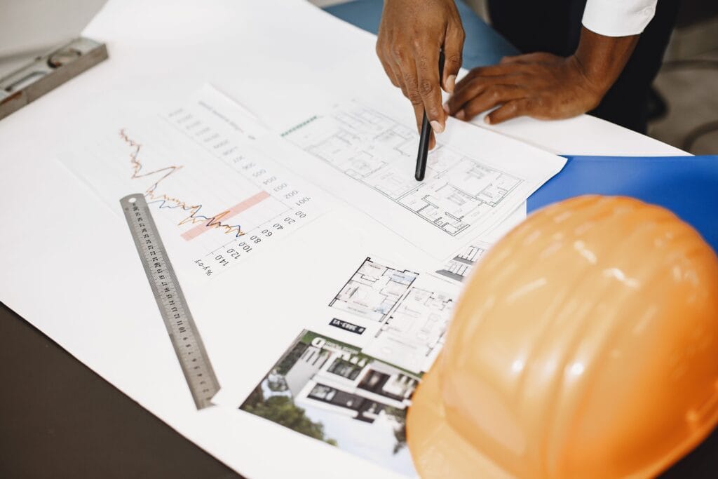 Architect analyzing building drawings with tools on a desk, showcasing planning and design